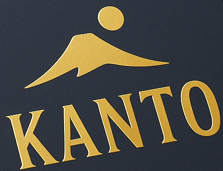 Close-up of the book cover: a gold mountain and sun above the word KANTO, stamped on dark navy cloth.